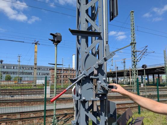 Formsignal, daran ist an der Seite ein dünner Hebel mit Handfalle angebracht. Dieser kann durch ein Riegelschloss in einer Position verriegelt werden.
