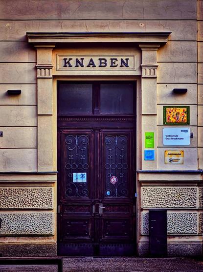 Die mit dem Wort Knaben überschriebene Eingangstür einer Volksschule in Graz.