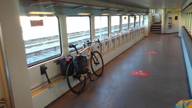 My bike leans on side wall of a train carriage that has capacity for 18 bikes.