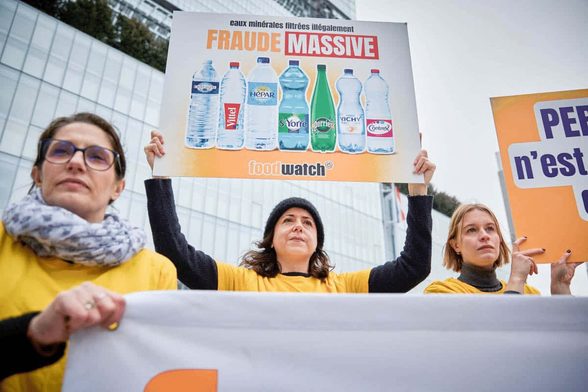 Des membres de l’ONG européenne Foodwatch se rassemblent devant le Tribunal de Grande Instance de Paris après que l’ONG a déposé une plainte contre Nestlé Waters et le groupe Sources Alma, en février 2024.