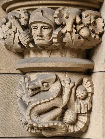 A decorative sculpted corbel featuring a dragon and a knight.