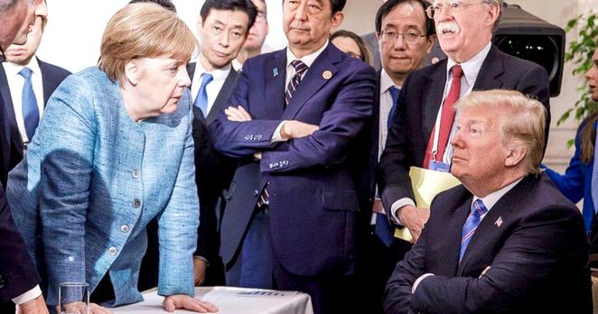 Merkel in front of some other State Leaders having a discussion with Trump. Merkel seems dominant, Trump Looks like a defiant Child.