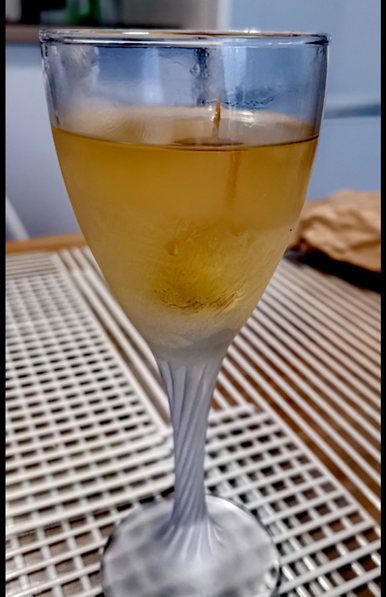 Il cocktail descritto nel toot, in un bicchiere nick&nora ghiacciato, con le olive infilate con uno stuzzicadenti