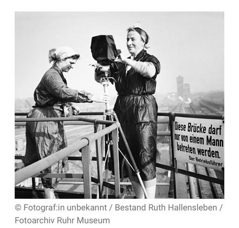Schwarz-weiß Foto undatiert, ca. 1940. Zwei Frauen, eine davon mit Kopftuch, stehen auf einer Brücke, um Fotos zu machen. Am Geländer der Brücke hängt ein Schild mit der Aufschrift: "Diese Brücke darf nur von einem Mann betreten werden."