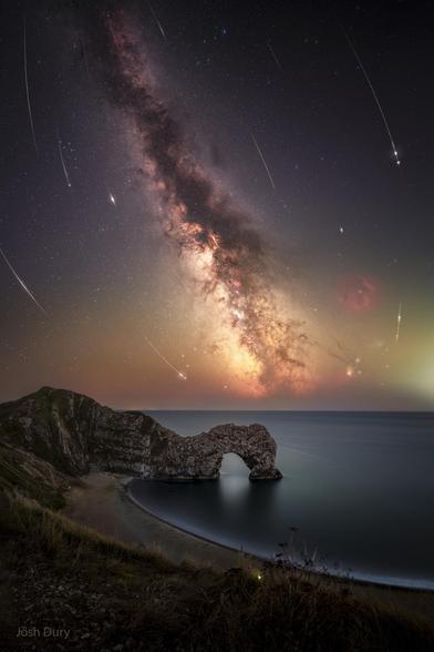 Perseid meteor shower and Milky Way behind a coastal foreground.