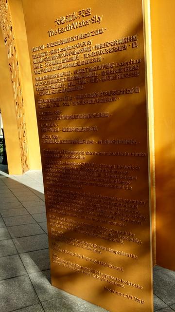Detailaufnahme einer großformatigen Stahlskulptur in rostgelb, mit der Inschrift. Der Text geht um Erde Himmel Wasser und ist unterschrieben von der Künstlering Josephine Chevry