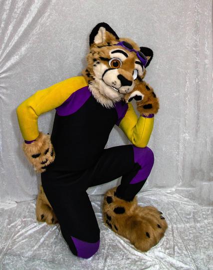 Photo of Obscura in fursuit partial and wearing a black/yellow/purple wetsuit