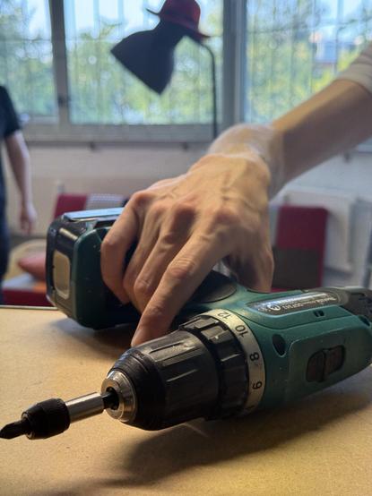 Een hand die accuboormachine oppakt