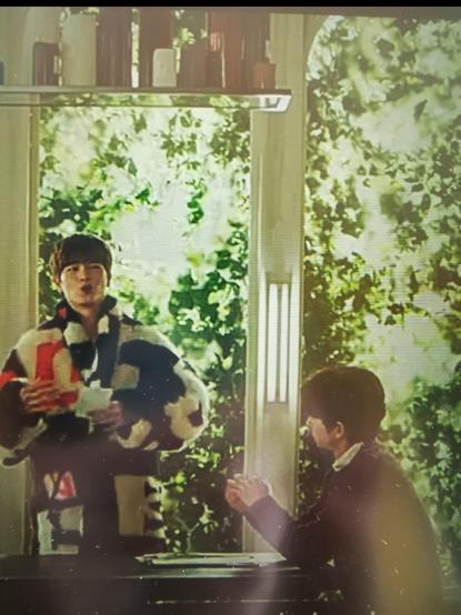 Foto of my tablet screen with the show on, paused. Two asian men with short hair talking. The older one sitting at a long table, the younger one standing, in the middle of speaking