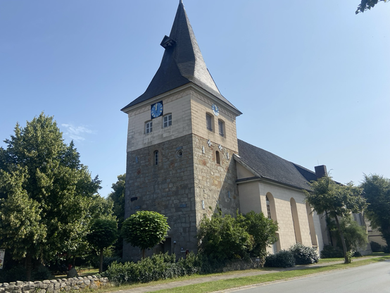 Eine Kirche, deren Turm im unteren Teil erkennbar viel älter ist als der Rest.