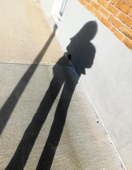 Autre autoportrait d’ombre. 
Cette fois, c’est l’effet “longues jambes” qui domine l’image. Un phénomène propre à une heure bien précise du jour, lorsque le soleil, encore vif, commence sa descente vers l’horizon. L’ombre s’étire et les proportions se transforment. 
Cheveux au vent, jambes longues : ainsi pourrait s’intituler cette photo.
© 2025, Chartrand Saint-Louis, photographie
