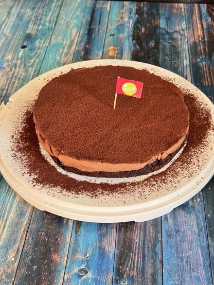 Schokokuchen aus zwei Schichten. Unten Schokoboden, darüber Schoko-Mousse und mit Kakao bestreut.