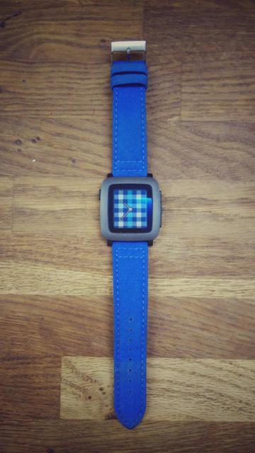 A Pebble Time watch with a blue wrist and a matching blue tartan-ish watchface