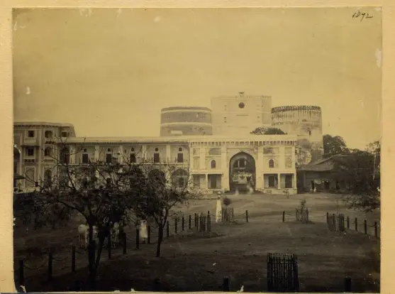 The image appears to be a historical photograph of a palace or fort complex, featuring a large building with multiple arches, towers, and a courtyard. The setting hints at a landscape with trees and possibly a garden, indicating it may have historical or architectural significance. The sepia tone suggests that it's an old photograph, likely taken in the 19th or early 20th century.

Image Credits: Wikimedia / Unknown authorUnknown author / Public domain