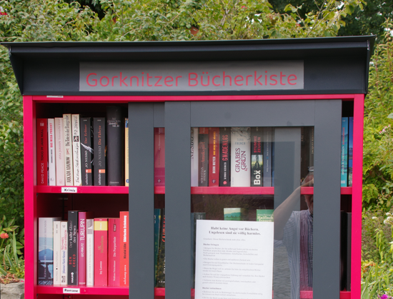 Ausschnitt aus einem rot/schwarzen Schrank mit Glasschiebetüren.