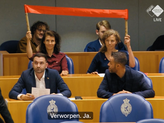 PvdD Kamerleden Esther Ouwehand & Christine Teunissen houden vanaf hun zetels een rood spandoekje (rode lijn) omhoog. Tijdens de motiestemmingen aan het einde van het Gazadebat in de Tweede Kamer. Kamervoorzitter Martin Bosma (PVV) onderbreekt zijn rede en de dames moeten het rode spandoekje snel inleveren.