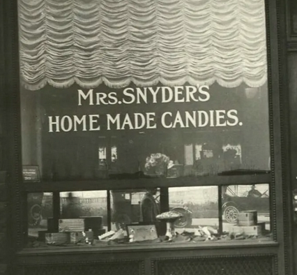 A storefront with the window lettering "Mrs. Snyder's Home Made Candies"
