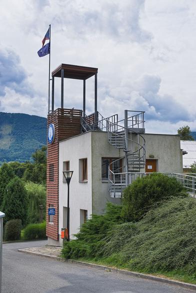 Pohled na budovu s rozhlednou zezadu. Ocelové točené přístupové schodiště.