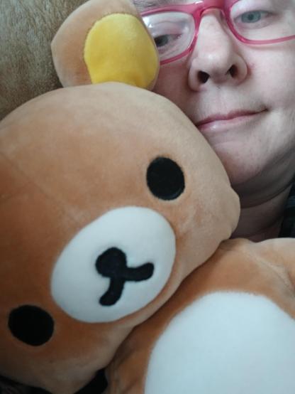 a rilakkuma teddybear next to the users face