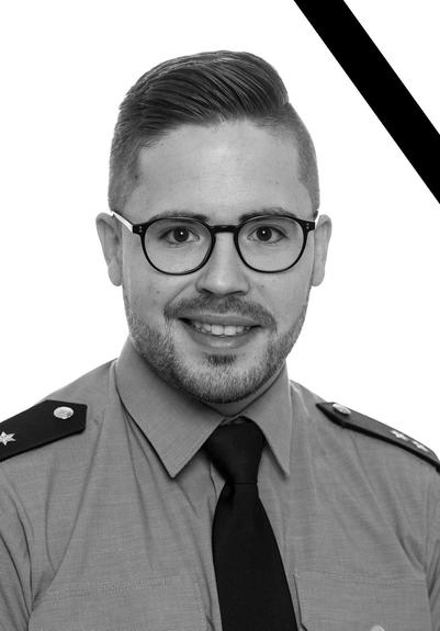 Das Foto zeigt Polizeioberkommissar Simon B. Er wurde in Ausübung seines Dienstes getötet. Das Bild ist in schwarz-weiß gehalten. In der Ecke, oben rechts, ist ein schwarzer Streifen.