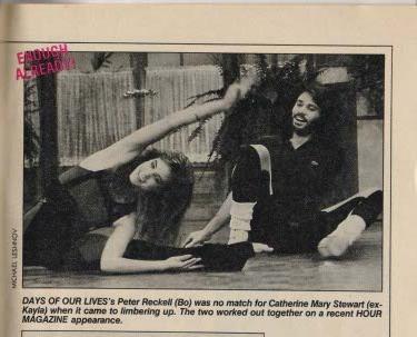 Vintage magazine clip showing Days of Our Lives stars Peter Reckell (Bo) and Catherine Mary Stewart (ex-Kayla) stretching on the floor during a joint appearance on Hour Magazine. Bo reaches upward in a stretch while Kayla sits with legs extended, hands on the floor. The caption playfully notes that Bo was no match for Kayla’s flexibility, adding a lighthearted moment to their legacy of emotional intensity and sibling drama.