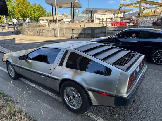 A person smiles after seeing a delorean on the street