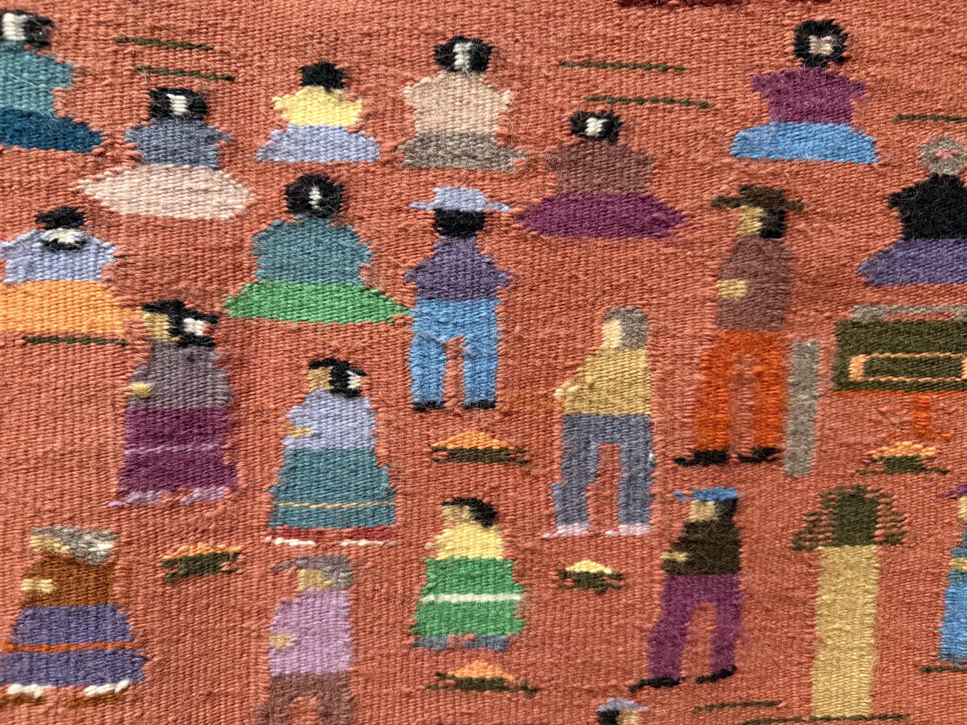 Detail of the pictorial weaving, showing a group of people wearing clothing of different colors. The people are rendered in simple stitches with minimal detail.
