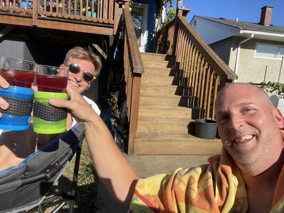 Me and the son clink glasses as we sit at the bottom of the deck stairs