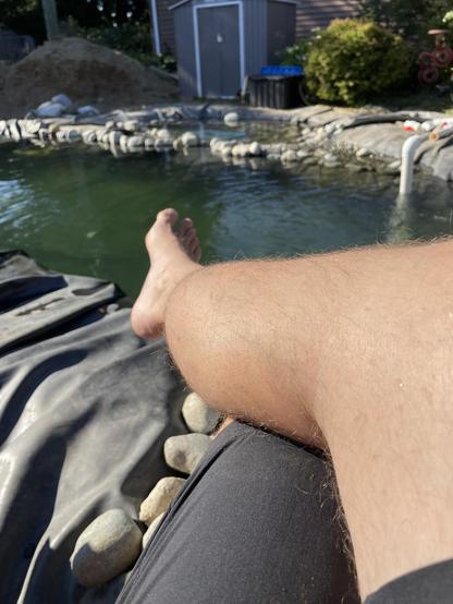 my leg and foot outstretched toward the water