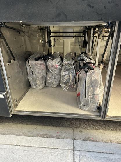 Five Brompton “Mobility Aids” folded in Dimpa bags in the bus cargo area.
