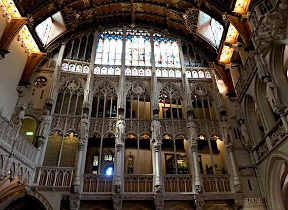 Foto van deel van hoge, grote hal in kasteel met veel versiering, beelden en bogen