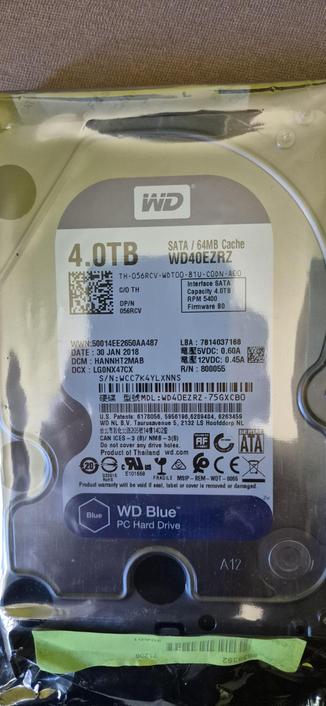 Foto der eingeschweißten Festplatte. Darauf der Produktaufkleber mit all den wichtigen Seriennummern und Details.