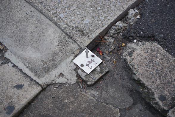 a waymarker, embedded in the concrete ground, points north?