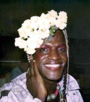 A photo of Marsha P. Johnson. By Pay It No Mind - Original publication: Pay It No Mind documentaryImmediate source: https://www.bet.com/photo-gallery/nl6dix/15-transgender-people-you-should-know/zx69ff, Fair use, https://en.wikipedia.org/w/index.php?curid=47771737