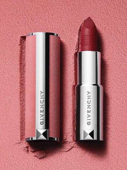 een lippenstift in een zilveren huls met een dop van zilver en roze leer