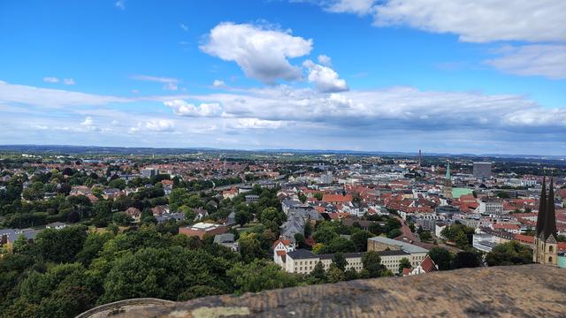 Blick von der Sparrenburg auf die Stadt Bielefeld..
Man sieht unter Anderem von links nach rechts gehend die Uni Bielefeld im Grünen, die hellblaue Alm, den Ostwestfalendamm, die vielen Hausdächer der Altstadt, das weiße Telekomhochhaus und die Altstädter Nikolaikirche mit den zwei markanten Kirchturmspitzen und den Wetterhähnen.