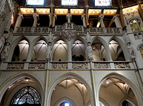 Foto van een kant van grote hal met gaanderijen met bogen