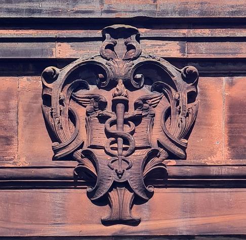 A relief sculpture of the Caduceus of Mercury on an Edwardian school in Glasgow.