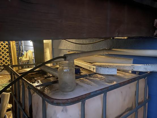 A large cube watering tank is underneath of our deck. There is a small hose going to the top of it.