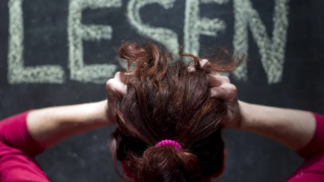 Frau vor dem Schriftzug »Lesen« (Symbolbild) Foto: Jens Büttner / DPA