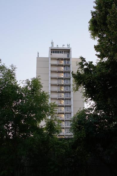 Turm von seiner schmalen Seite aus, beleuchtetes Treppenhaus und Antennen auf dem Dach