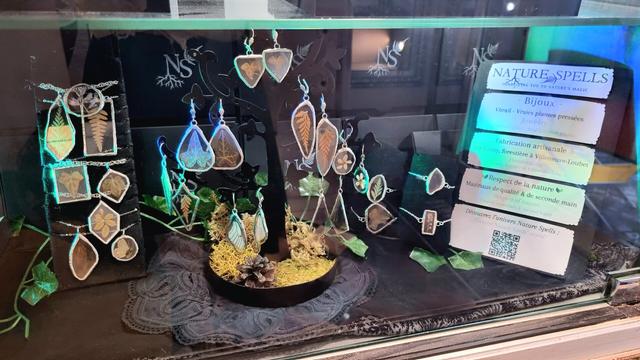 English Closeup on a store window full of jewelry: bracelets, necklaces and earrings made of stained glass and real pressed plants and insects wings.
Français Gros plan sur une vitrine de magasin pleine de bijoux : bracelets, colliers et boucles d'oreilles en vitrail et avec de vraies plantes et ailes d'insectes pressées.