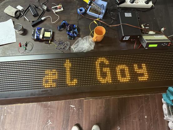 Een bureau vol met electronica, en een BUS led lbord met de tekst "'het goy"