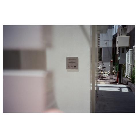 The silver plaque on the white toilet building names the designer, Kashiwa Sato.