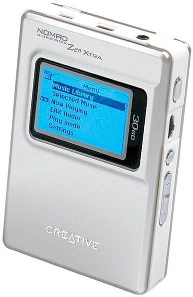 A silver Creative Nomad Jukebox Zen Xtra portable MP3 player with a small rectangular screen displaying a blue menu. The menu shows options like Music Library, Now Playing, EAX Audio, Play Mode, and Settings. The device has a 30 GB capacity printed on the side and physical buttons along the right edge.