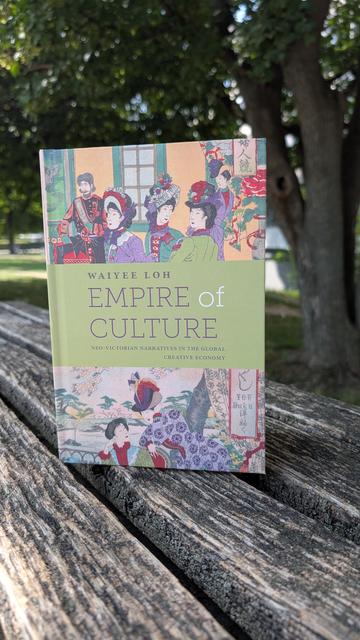 Waiyee Loh's book "Empire of Culture" on a wooden bench in a park setting