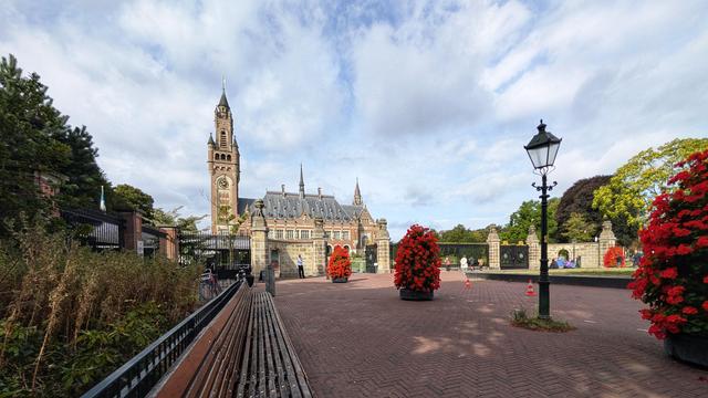 Front view, including formal gardens, gate and public square of the Peace Palace in The Hague.
