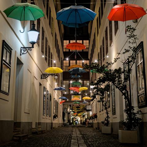 Foto der Passage bei Nacht, bunte Regenschirme hängen oberhalb