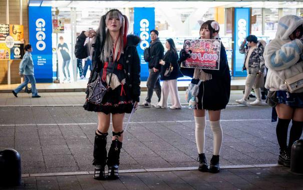 Dues noies vestides de maidos modernes, publicitant el preu per hora del seu local, als carrers de Kabukicho.