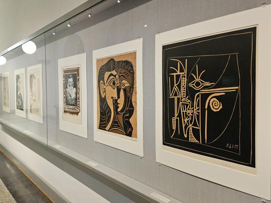 Glasvitrinen an einer Wand mit Druckgrafiken